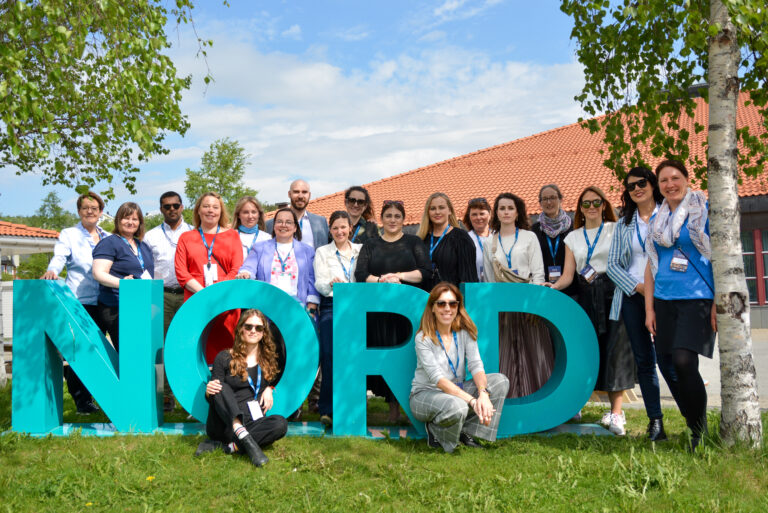 Members of the technical team pose behind Nord logo