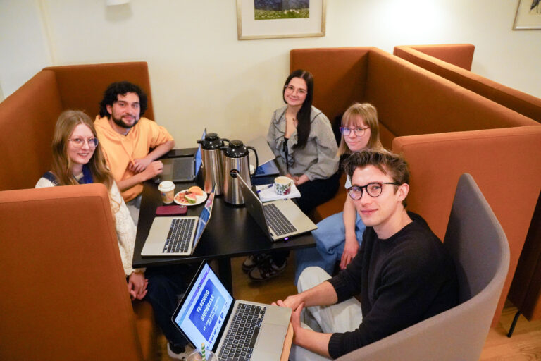 Students in a group discussion, using laptops